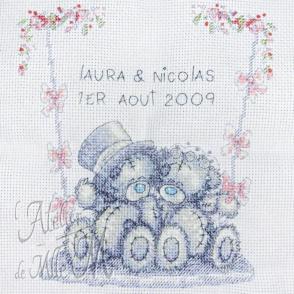 Tableau de mariage "Me to you". Gros plan sur la broderie avant encadrement de deux petits oursons "Me to you" sur une balançoire le jour de leur mariage. Composition : Point de croix compté sur toile aïda. Fils de coton mouliné. Réalisation suivant une grille trouvée sur internet.