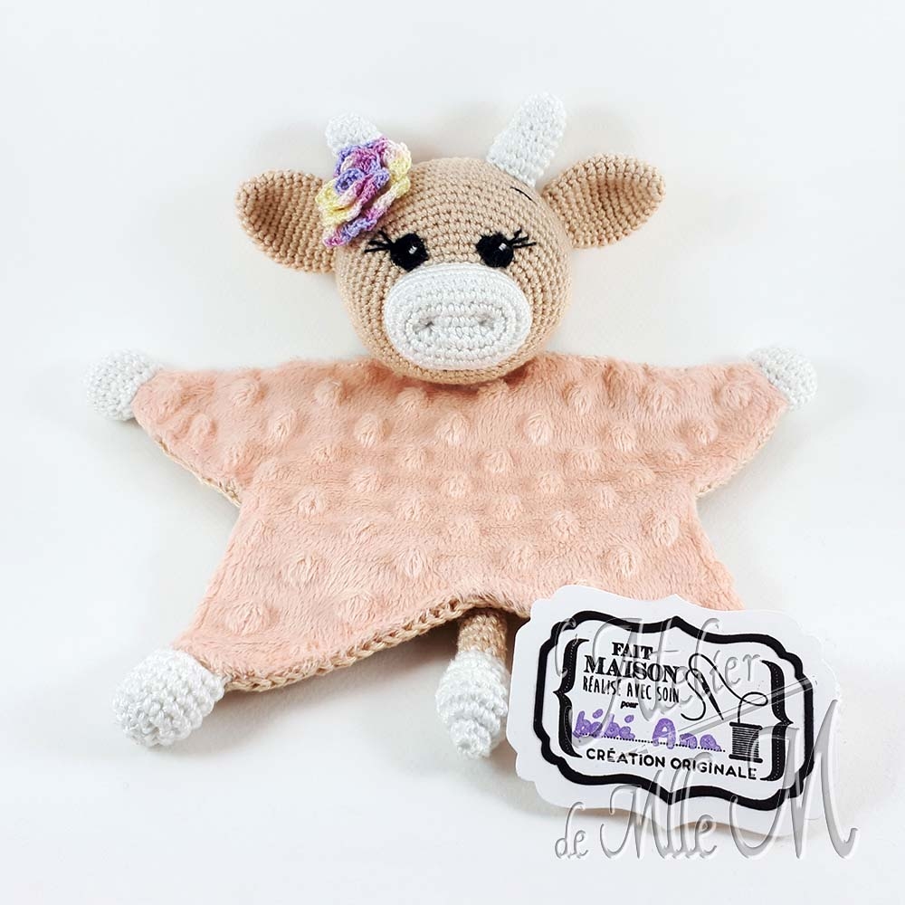 Une petite vache doudou réalisée au crochet pour un bébé nouveau né. Elle a un ventre tout doux grâce au tissu 'Minky'. Composition : Fil 100% coton et rembourrage polyester. Ventre en tissu 'Minky'. Yeux brodés en coton N°12. Fleur crocheté en coton N°12. Dimensions : 23,5 (H) x 24 (l) cm. Article disponible sur le Blog dans la catégorie Amigurumi.