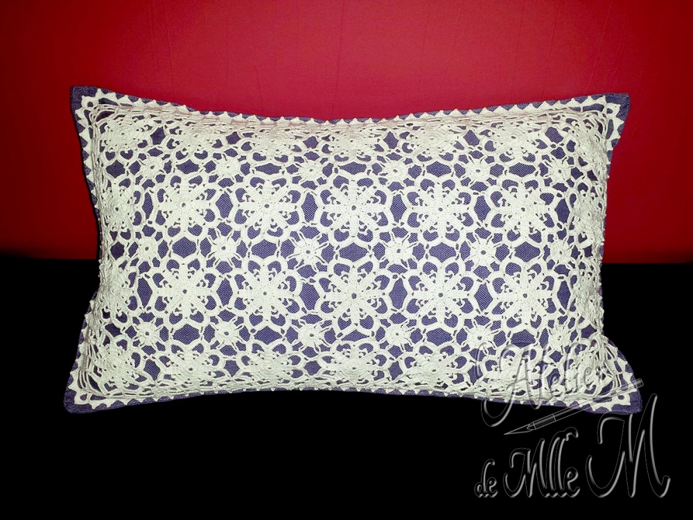 Un motif réalisé au crochet, puis cousu sur une housse de coussin 30x50 cm. Composition : Coton N°12. Motif floral trouvé sur internet. L'assemblage et les autres motifs sont improvisés.