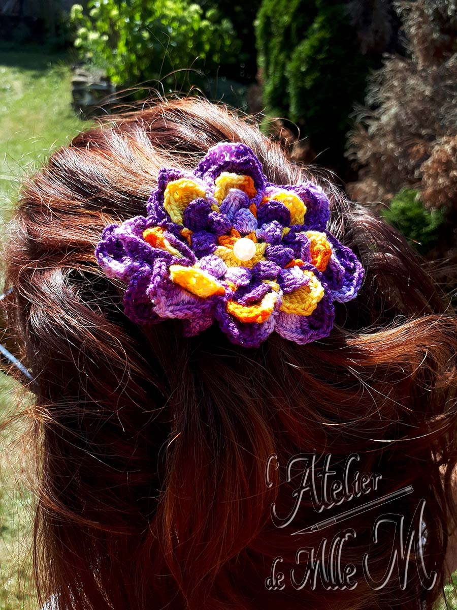 Une barrette en forme de fleur bicolore et son cœur en perle nacrée. Composition : Fil 100% coton perlé N°5. Support de barrette en métal. Perle. Fleur réalisée et adaptée d'après le tuto vidéo de NotikaLand crochet and knitting : https://youtu.be/nYw0kISAtCM