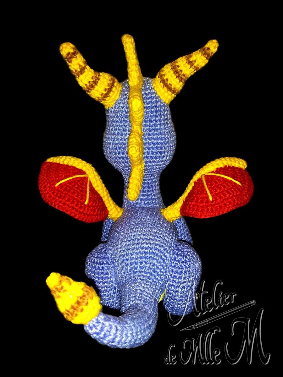 Dragon Spyro. Une représentation assez fidèle du dragon du célèbre jeu vidéo. Composition : Fil 100% coton et rembourrage polyester. Yeux brodés en coton mouliné. Dimensions : 19 x 15 x 18 cm.