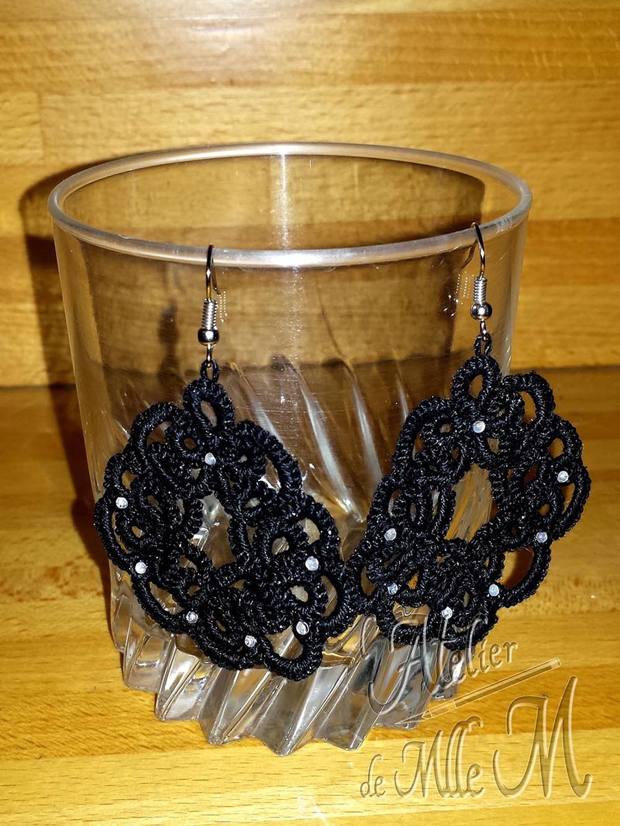 Boucles d'oreilles noires avec strass. Composition : Frivolité à l'aiguille. Fil de coton Rico Glitz n°10. Strass de 2mm collés à la super glue. Réalisation suivant un patron gratuit trouvé sur internet.