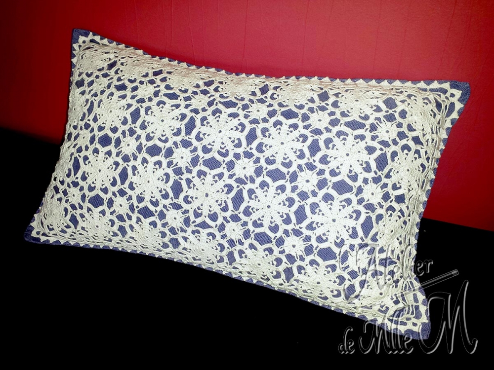 Un motif réalisé au crochet, puis cousu sur une housse de coussin 30x50 cm. Composition : Coton N°12. Motif floral trouvé sur internet. L'assemblage et les autres motifs sont improvisés.