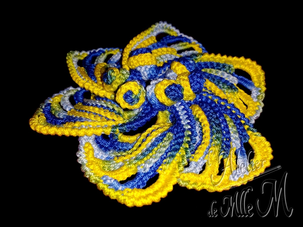 Une fleur à 6 pétales bleues et jaunes réalisée au crochet ; à monter en barrette, en broche, ou à utiliser en déco. Composition : Coton perlé N°5 changeant de couleur. Fleur réalisée suivant le patron gratuit (en anglais) de Sheruknittingcom : https://youtu.be/wOeZq7OCeGA