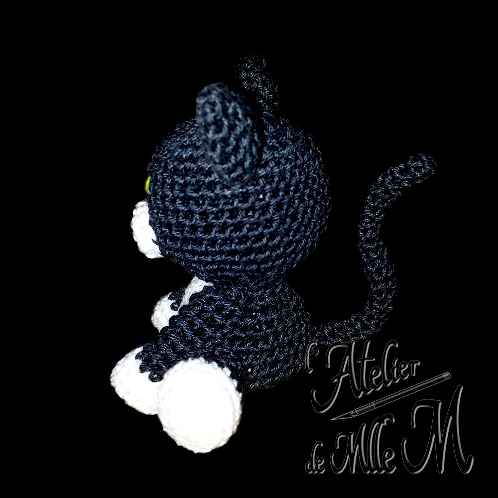 Minou Choo. Un petit chat noir aux chaussettes blanches. Création appartenant à la gamme des "Amis Choo". Composition : Fil 100% coton et rembourrage polyester.