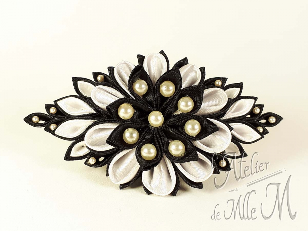 Une belle barrette noire & blanche rappelant une fleur, réalisée suivant l'art tsumami zaiku. Composition : Rubans de satin - Perles nacrées. Support de barrette en métal. Une revue complète à lire pour rétablir la vérité sur les Tsumami zaiku et les Kanzashi disponible sur https://www.latelierdemllem.com/verite-sur-tsumami-zaiku-kanzashi/